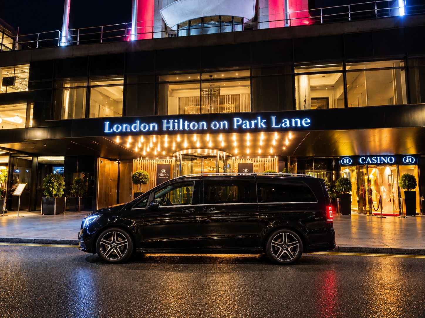 Black Mercedes V-Class outside the London Hilton on Park Lane at night